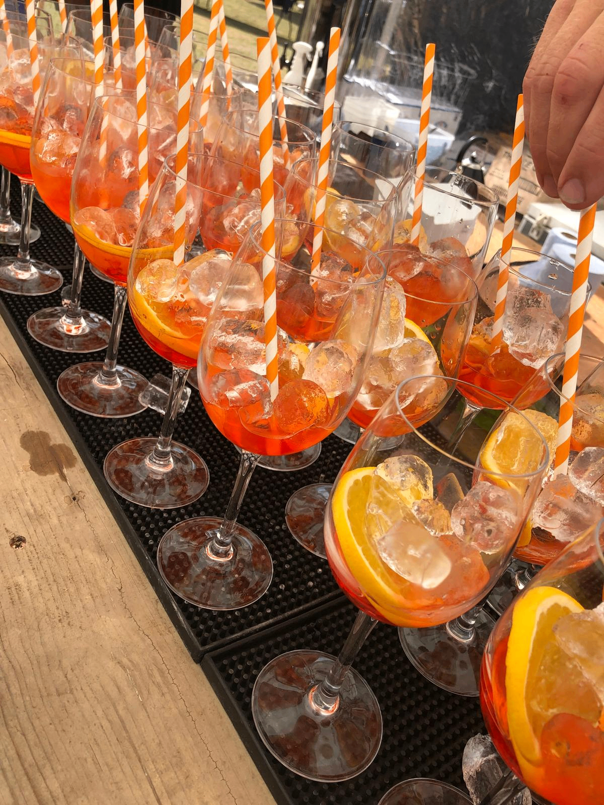 Aperol spritz drinks lined up on a wedding bar ready for service