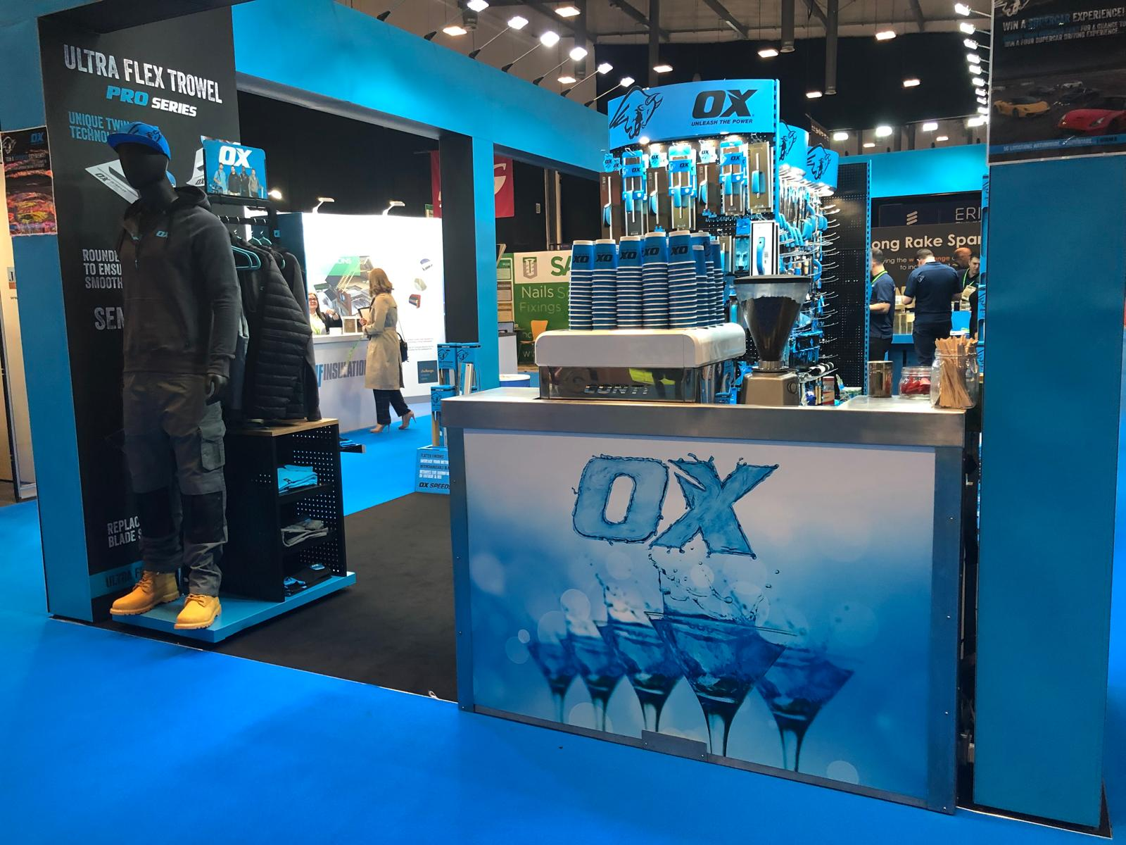 OX Tools branded mobile bar at a trade show with full back-bar setup and coffee machine