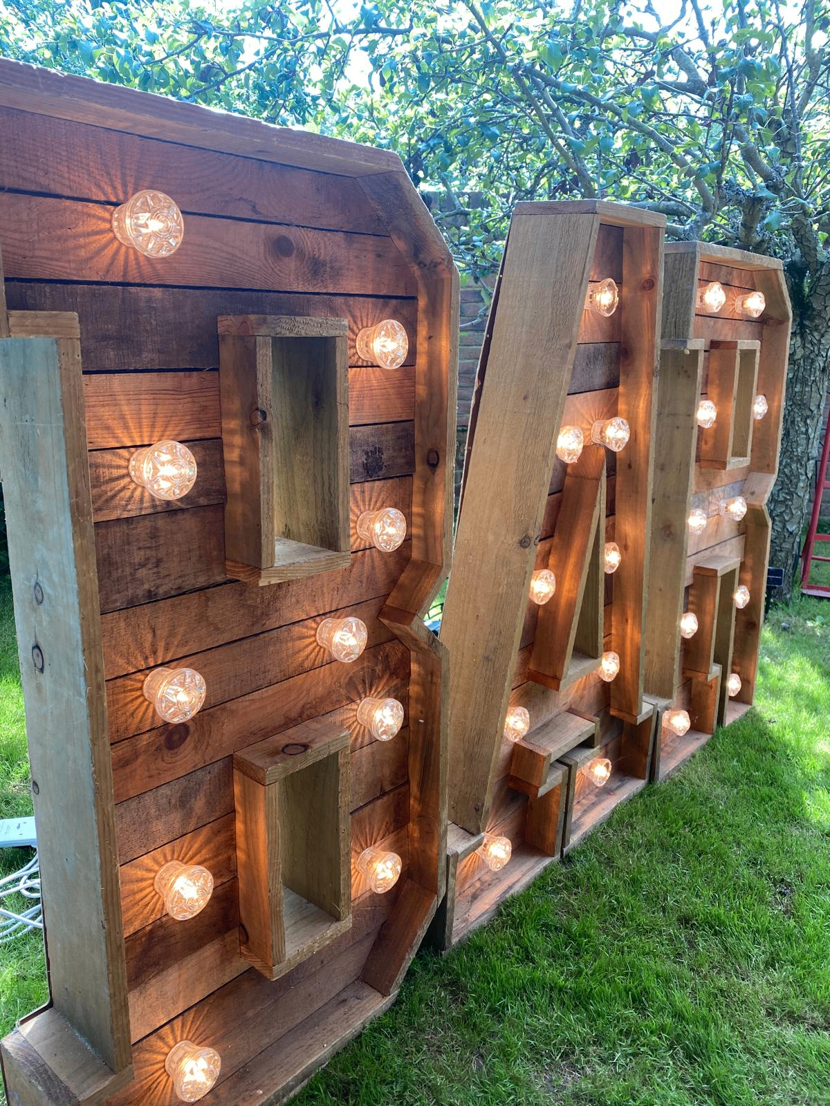 Illuminated wooden BAR marquee letters dressed at a wedding reception