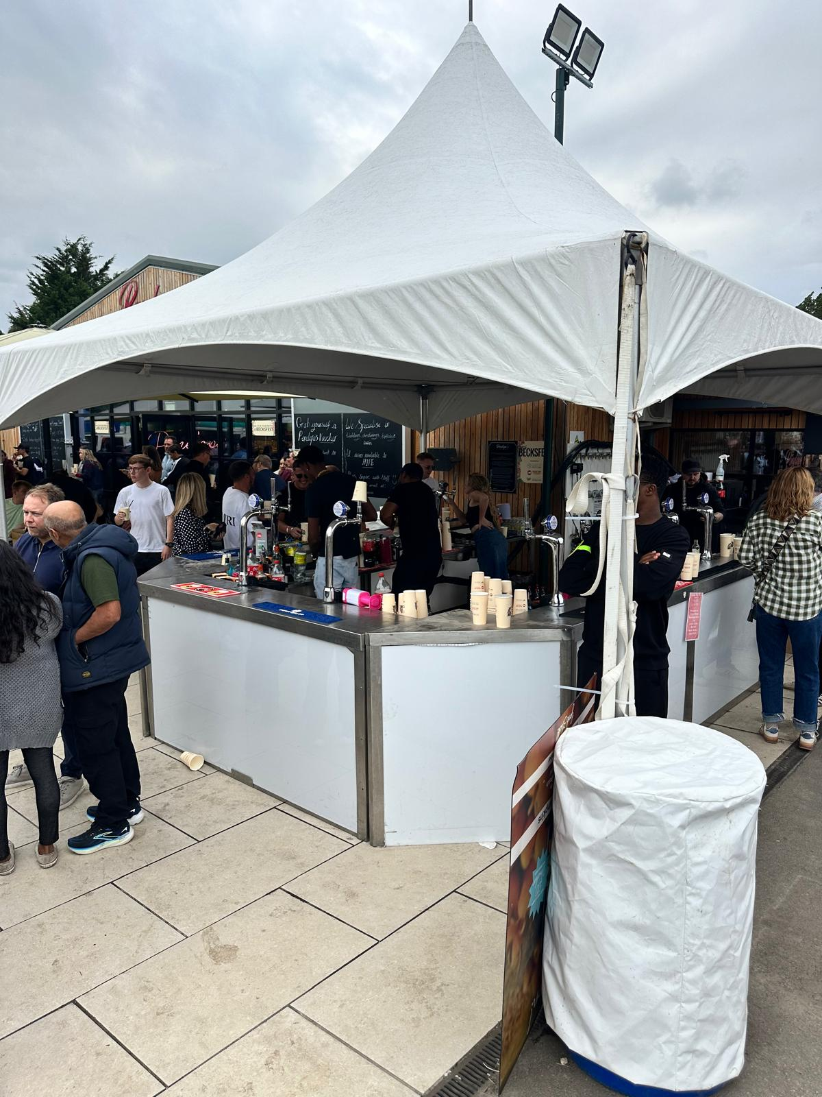 Becksfest multi-tap pagoda festival bar serving queueing crowds outdoors