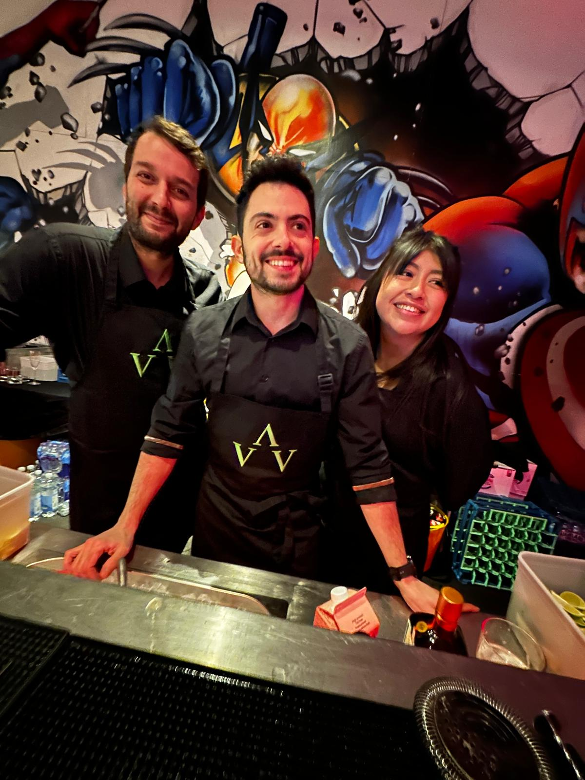 Three bar staff behind the bar at a live event