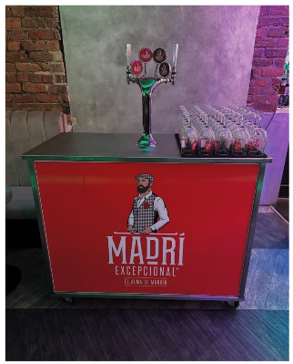 Red Madrí-branded mobile beer tap bar with green keg fonts and pint glassware