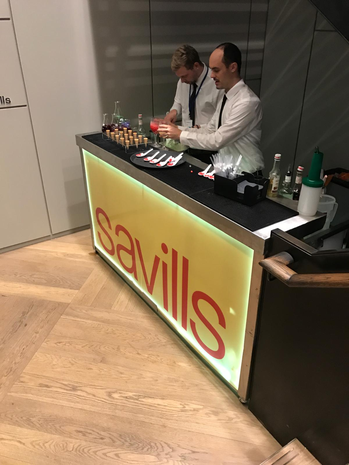 Savills branded mobile bar in service with two bartenders at a corporate event