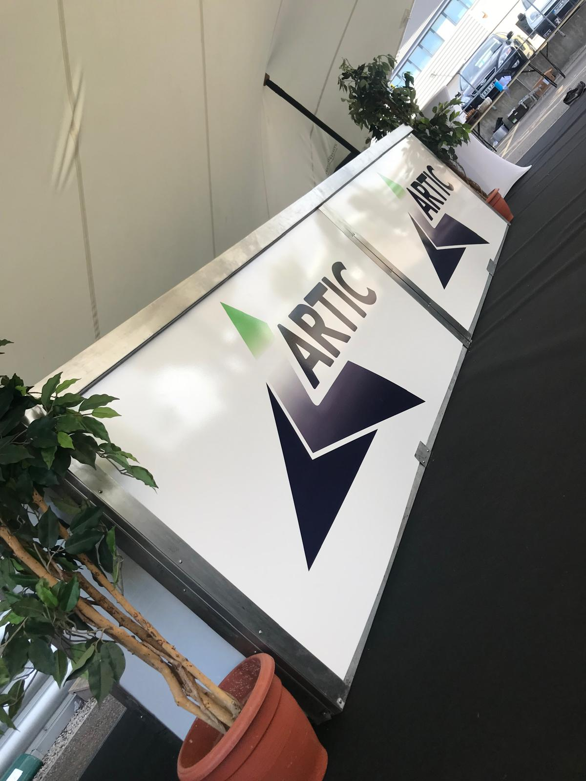 Artic branded white mobile bar panels installed inside a corporate event structure